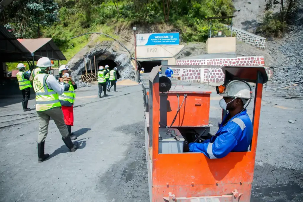 Pekerja tambang di lokasi penambangan terbuka dengan jalur rel transportasi material